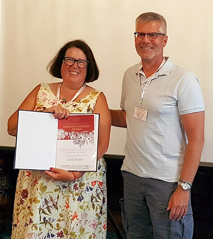 Linda Beutler receiving her Golden Clematis Award from our President, Jeff Jabco, in Scotland, July 2018